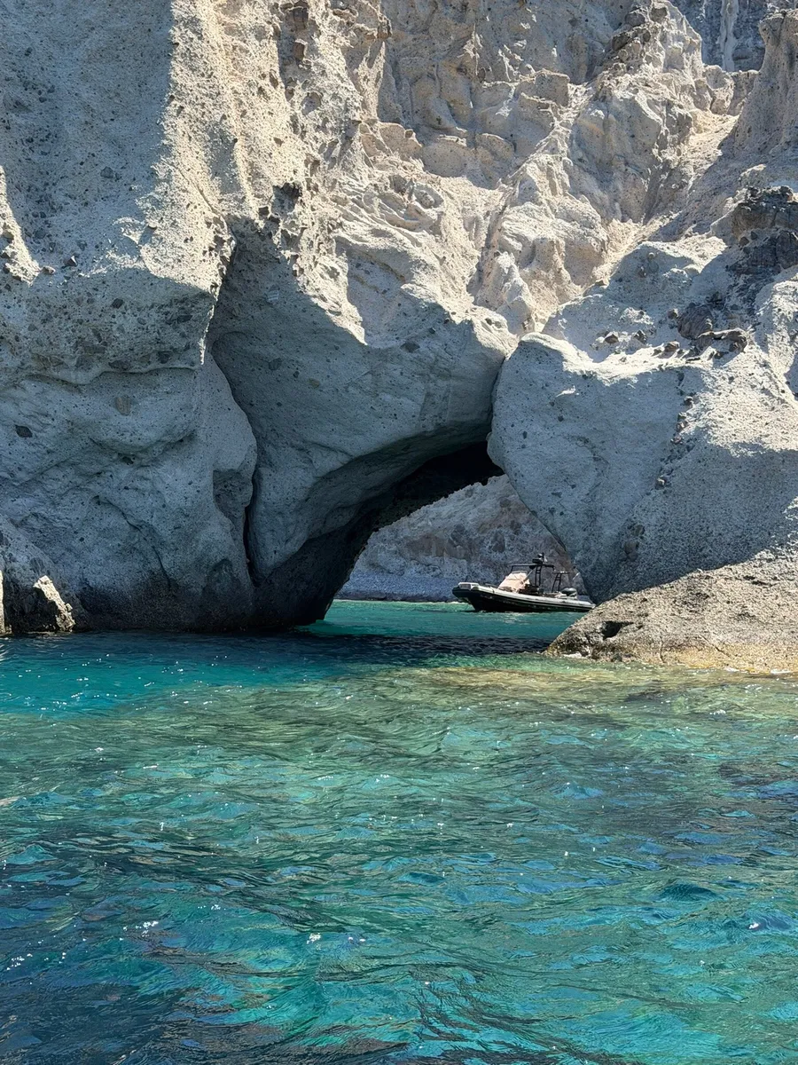 Turquoise water under a white rock arch