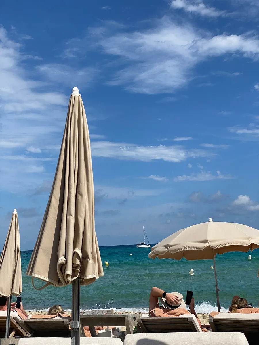 Straw and white umbrellas on the beach