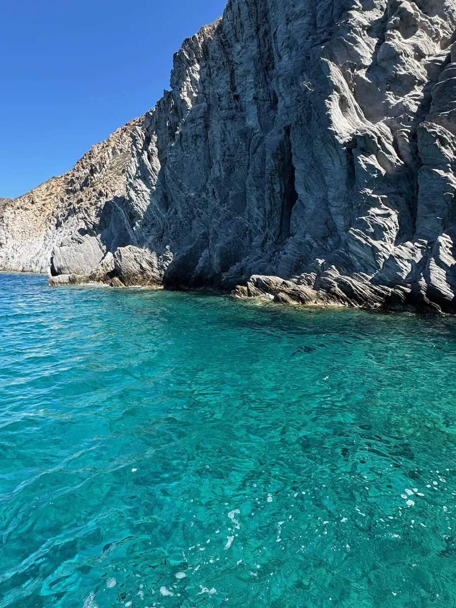 A grey cliff over turquoise water